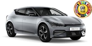 Mitcar Warszawa | Salon i Serwis KIA i Subaru | Srebrna kia ev6 z odznaką najlepszego auta roku 2022 na białym tle w salonie Mitcar.Warszawa.